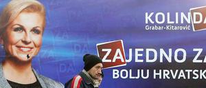 Zwei Kroaten in Zagreb (Archiv). Gehören sie zu den "Glücklichen", denen die Schulden von der Regierung erlassen werden? Im Hintergrund ein Wahlplakat der aktuellen Präsidentin Kroatiens, Kolinda Grabar Kitarovic.
