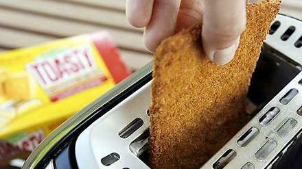 Eine Scheide Toast wird in einen Toaster gesteckt