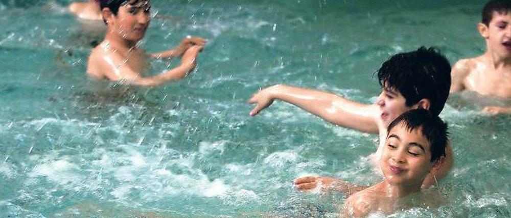 Schulkinder planschen in einem Schwimmbecken