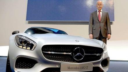 Sportlich unterwegs. Dieter Zetsche mit neben einem Mercedes-AMG GT Sportwagen.