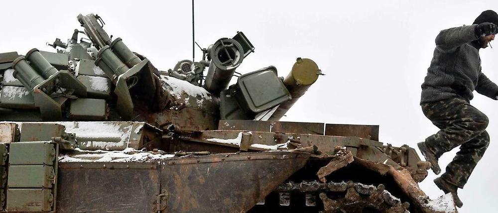 Ein ukrainischer Soldat springt am Dienstag von einem in Kämpfen mit Separatisten stark beschädigten Panzer.