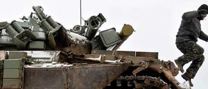 Ein ukrainischer Soldat springt am Dienstag von einem in Kämpfen mit Separatisten stark beschädigten Panzer.
