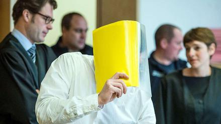 Der Angeklagte Mario K. verdeckt sein Gesicht im "Maskenmann"-Prozess im Landgericht in Frankfurt (Oder).