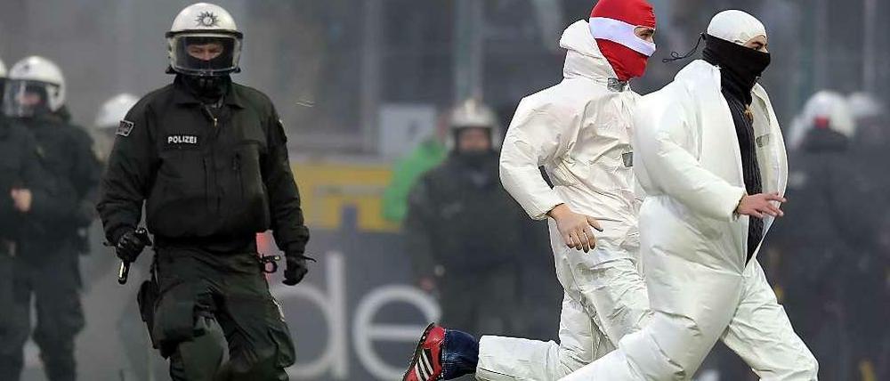 Nach dem Abpfiff der Partie Gladbach gegen Köln stürmten etwa 30 Hooligans in weißen Anzügen das Spielfeld.