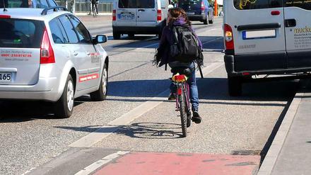Radfahrerin muss in Berlin in der Radspur einem parkenden Lieferwagen ausweichen.