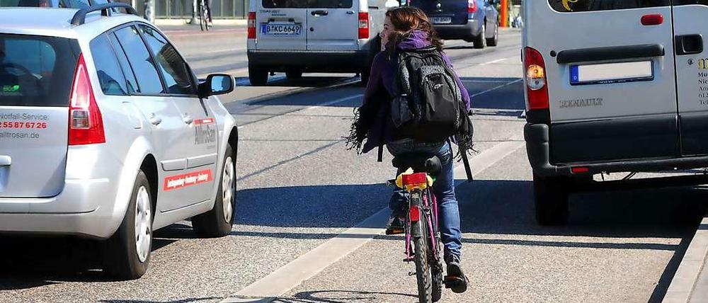 Radfahrerin muss in Berlin in der Radspur einem parkenden Lieferwagen ausweichen.