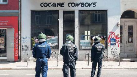 Aufpasser, aufgeputscht? Ein leerer Laden liefert eine zweideutige Überschrift zu dieser Szene am Rande eines Protestes.