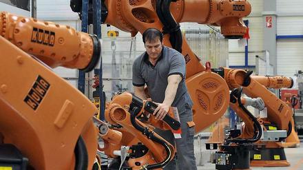 Sie übernehmen körperliche, aber auch zunehmend geistige Tätigkeiten: Roboter, Computer und Maschinen, hier an einer Produktionsstrecke in Augsburg.