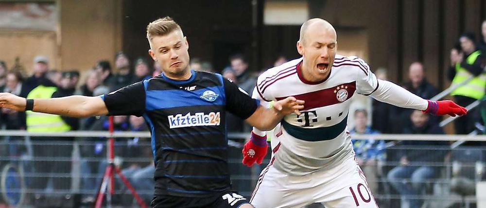 Wenn ein Paderborner (Hartherz, links, gegen Robben) eine Notbremse begeht, gibt es Elfer und Rot. Wenn es ein Dortmunder tut, nur Elfmeter.