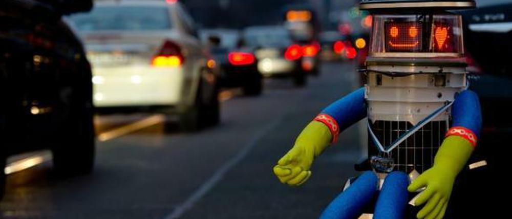 Hitchbot ist in Deutschland und sitzt am Straßenrand.