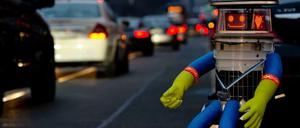 Hitchbot ist in Deutschland und sitzt am Straßenrand.