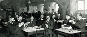 Altberliner Art. Berliner Weiße wird 1903 aus flachen Trinkgefäßen mit einem Umfang von Suppenschüsseln getrunken. Die Gäste der Weißbierstube haben mit dem Biergenuss alle Hände voll zu tun.