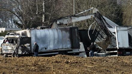 Polizeibeamte untersuchen die beiden überfallenen Transporter an der Autobahn. 