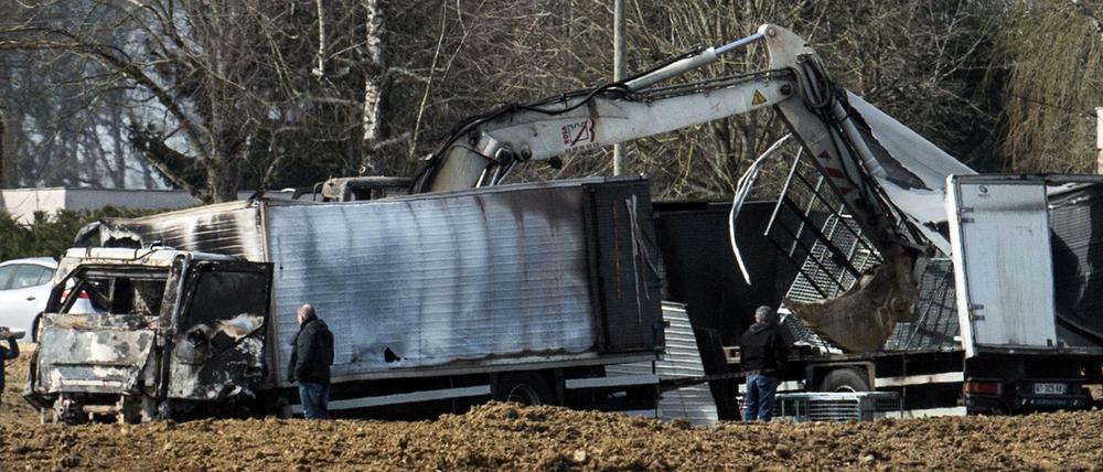 Polizeibeamte untersuchen die beiden überfallenen Transporter an der Autobahn.