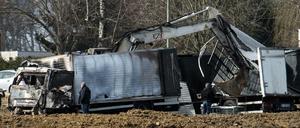 Polizeibeamte untersuchen die beiden überfallenen Transporter an der Autobahn. 