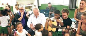 Alle mal mitklatschen. In der Vorschule des Förderprojektes vom Instituto Marquês de Salamanca für Kinder aus der Favela im Bezirk Santa Teresa in Rio de Janeiro, Brasilien, wird der Besuch aus Deutschland herzlich empfangen. FürSpendenprojekt "Tabalugahaus" von Hans Georg Näder (Schal), Peter Maffay (mit Gitarre) und Eva Hassmann (rechts hinten) in Kooperation mit dem Instituto Marquês de Salamanca (Förderer Olavo Egydio Monteiro de Carvalho, weißes Hemd) gab es Applaus. Der Tagesspiegel ist Medienpartner des Hilfsprojektes. Und Joachim Löw machte auch mit. 
