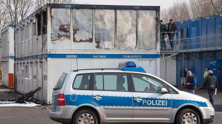 Polizeibeamte untersuchen am Dienstag ausgebrannte Wohncontainer auf dem Gelände der zentralen Aufnahme- und Ausländerbehörde im niedersächsischen Bramsche bei Osnabrück.