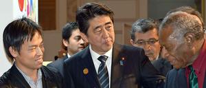 Auf der UN-Weltkonferenz zur Reduzierung der Risiken durch Naturkatastrophen im japanischen Sindai bietet der Premierminister von Japan, Shinzo Abe (m), dem Präsidenten von Vanuatu, Baldwin Lonsdale (r), eine Erdbeere an.