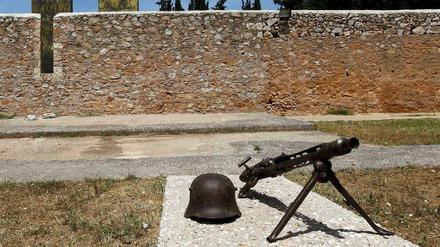 Ein Helm und ein Maschinengewehr, so wie sie von den deutschen Soldaten im Zweiten Weltkrieg benutzt worden sind, im Skopeftirio Park in Athen. Hier wurden 1100 Griechen hingerichtet.