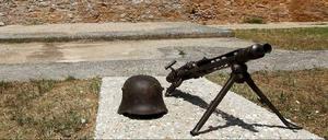Ein Helm und ein Maschinengewehr, so wie sie von den deutschen Soldaten im Zweiten Weltkrieg benutzt worden sind, im Skopeftirio Park in Athen. Hier wurden 1100 Griechen hingerichtet. 