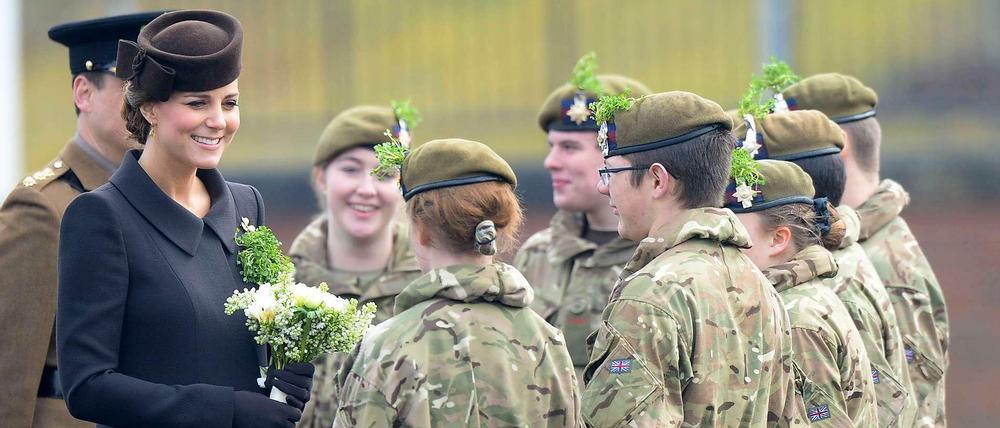 Die schwangere Herzogin Kate verteilt Kleeblätter an Soldaten. 