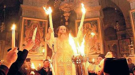 Griechisch-orthodoxe Mönche feiern die Auferstehung Christi mit dem Wunder des heiligen Feuers. 