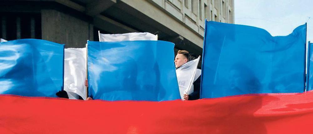 Rot, weiß, blau. In Simferopol feierten Bürger den Jahrestag der Annexion mit Flaggen in den russischen Nationalfarben.