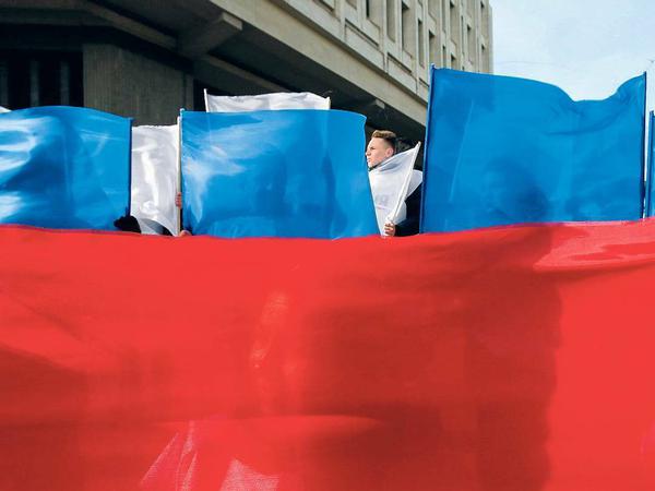 Rot, weiß, blau. In Simferopol feierten Bürger den Jahrestag der Annexion mit Flaggen in den russischen Nationalfarben.