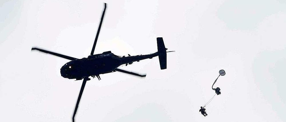 Ein Fallschirmspringen springt aus einem Hubschrauber des Typs "Black Hawk".