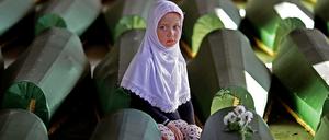 Ein Mädchen sitzt im Potocari Memorial Center an einem der 173 Särge mit Opfern aus Srebrenica, die zuletzt identifiziert worden waren. 