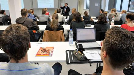 Ein Professor steht im Seminar vor Studierenden.