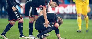Drüber und vorbei. Der Leverkusener Stefan Kießling (u.) muss nach seinem entscheidenden Fehlschuss getröstet werden.
