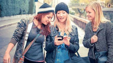 Chillen. Junge Mädchen suchen auf ihrem Smartphone nach der nächsten Party oder einem Partner für ein Date. 