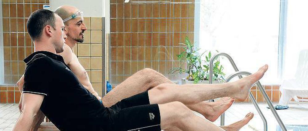 Trockenübung. Schwimmtrainer Alexander Steinhart zeigt Redakteur Björn Seeling den richtigen Beinschlag.