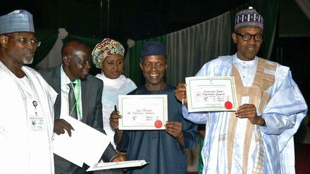 Am Mittwochabend hat der Chef der unabhängigen Wahlkommission Inec, Attahiru Jega (links), dem künftigen Präsidenten Muhammadu Buhari (rechts) und seinem designierten Vizepräsidenten Yemi Osinbanjo (links neben ihm) ihre Urkunden über den Wahlausgang ausgehändigt. Im Hintergrund steht Aisha Buhari. 