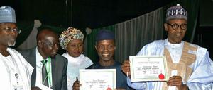 Am Mittwochabend hat der Chef der unabhängigen Wahlkommission Inec, Attahiru Jega (links), dem künftigen Präsidenten Muhammadu Buhari (rechts) und seinem designierten Vizepräsidenten Yemi Osinbanjo (links neben ihm) ihre Urkunden über den Wahlausgang ausgehändigt. Im Hintergrund steht Aisha Buhari. 
