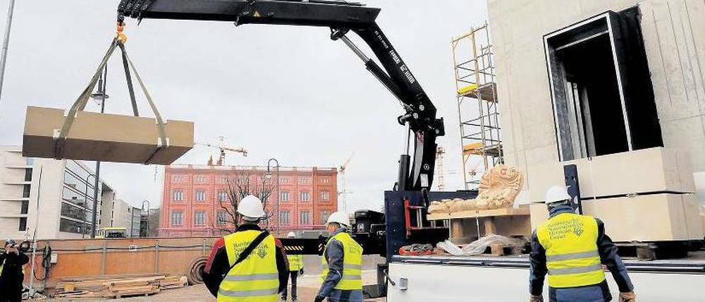 Der erste Sandsteinblock wird vom Lkw gehoben.