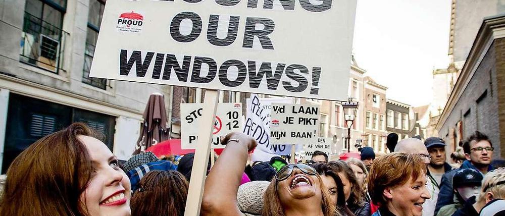 "Stop Closing Our Windows!", steht auf diesem Schild einer Demonstrantin. Gemeinsam mit mehr als hundert anderen Menschen demonstriert sie gegen die Schließung von Rotlicht-Fenstern in Amsterdam. 