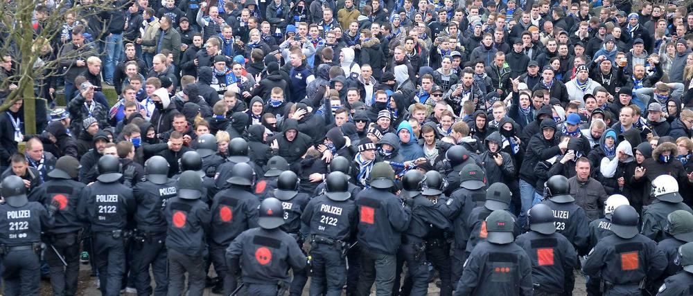 Zahlreiche Polizisten trennen Fußballfans des Hamburger SV von Fußballfans von Werder Bremen am 01.03.2014 am Weserstadion in Bremen.