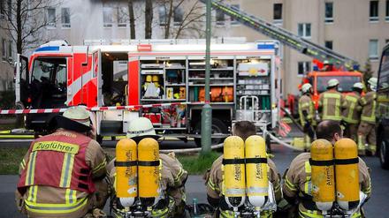 Feuerwehrleute ruhen sich Dienstagabend vom Einsatz am Flüchtlingsheim aus. 