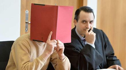 Hinter Akten. Der Angeklagte Björn K. und sein Anwalt im Gericht.