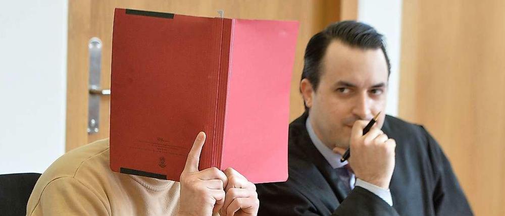 Hinter Akten. Der Angeklagte Björn K. und sein Anwalt im Gericht.