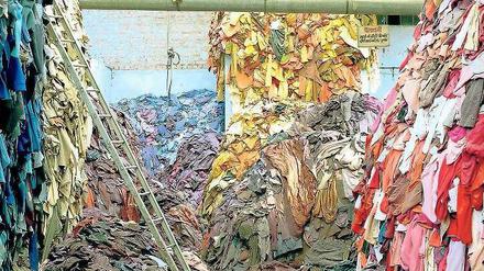 Klederberge türmen sich in einer Fabrikhalle in Indien auf