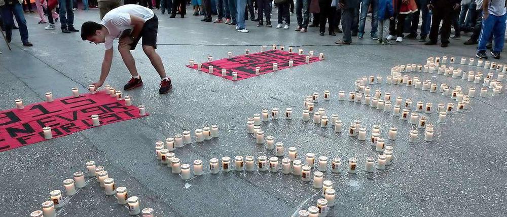 Ein Armenier stellt vor der türkischen Botschaft in Athen Kerzen auf - zum Gedenken an den Völkermord des Osmanischen Reichs an den Armeniern.