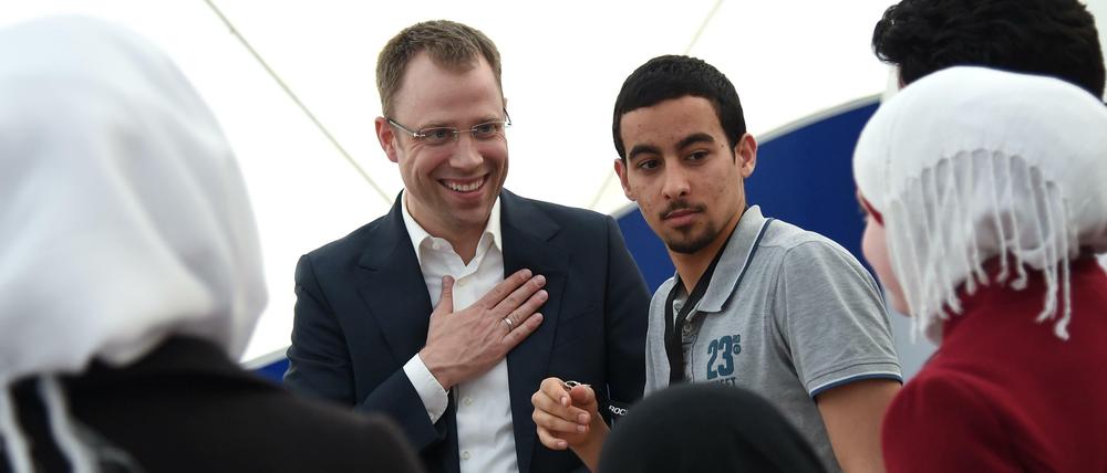 Auf Tuchfühlung. Senator Mario Czaja unterhält sich bei seinem Besuch einer Notunterkunft für Flüchtlinge am Donnerstag mit einer syrischen Familie.