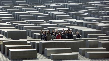 Eine Schulklasse steht inmitten des Stelenfeldes des Holocaust-Mahnmals in Berlin.