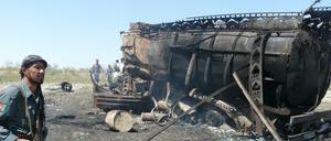 Ein afghanischer Polizist vor einem der zerstörten Tanklastzüge nach dem Angriff nahe Kundus im September 2009