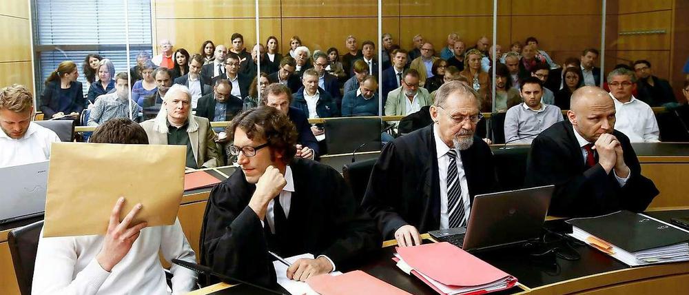 Ein Blick in den Gerichtssaal: Der Angeklagte Sanel M. verdeckt sein Gesicht. Neben ihm sein Anwalt Stephan Kuhn.