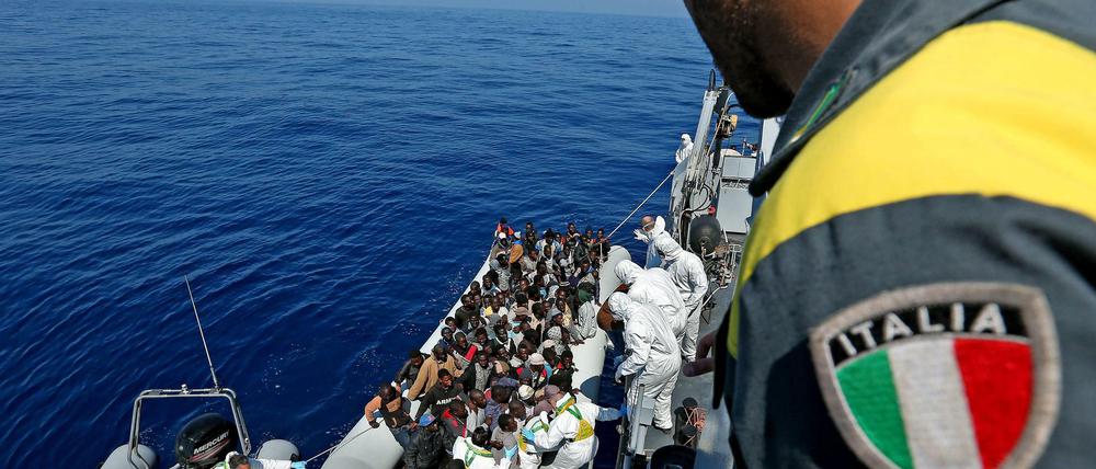 Ein italienisches Rettungsschiff nimmt auf dem Mittelmeer Flüchtlinge an Bord.