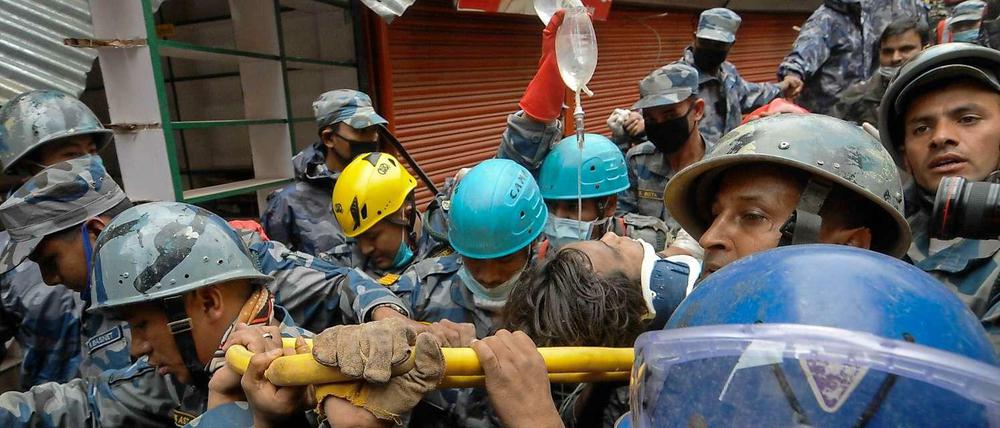 Rettungskräfte in Nepal tragen einen 18-Jährigen auf einer Bahre, der fünf Tage in den Trümmern überlebt hatte. 